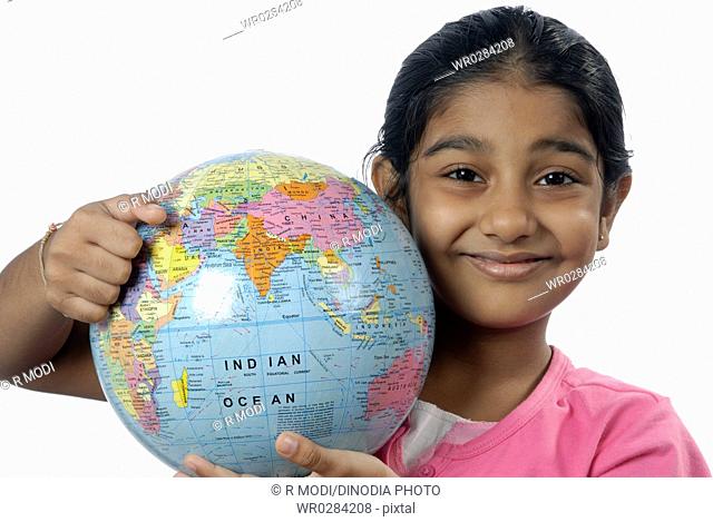 South Asian Indian six year old girl holding globe on shoulder MR152