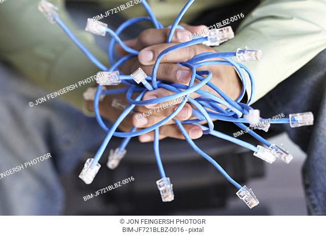 Close up of hands holding Ethernet cables