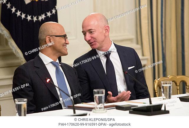 Microsoft CEO Satya Narayana (L) and Amazon CEO Jeff Bezos chat during an American Technology Council roundtable with corporate and eduction leaders at The...
