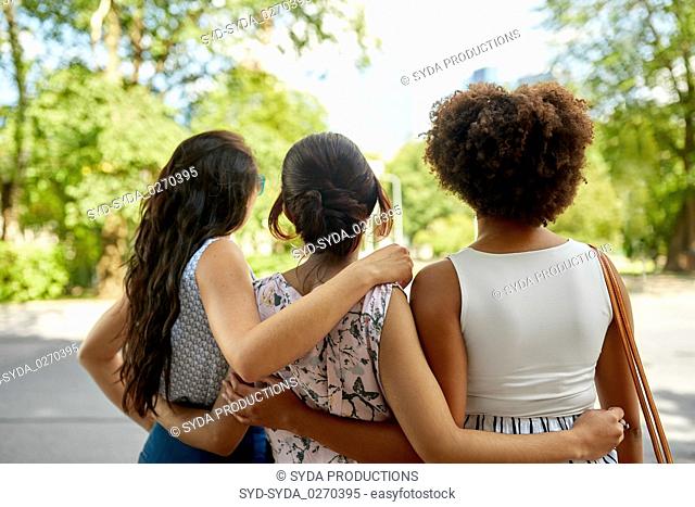 young women or friends hugging at summer park
