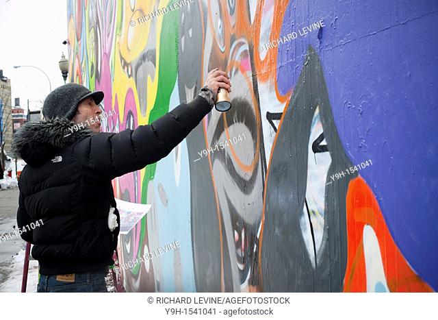 The artist Kenny Scharf repairs his mural at the corner of Bowery and Houston Street in New York The space, which is famous for hosting murals by graffiti...