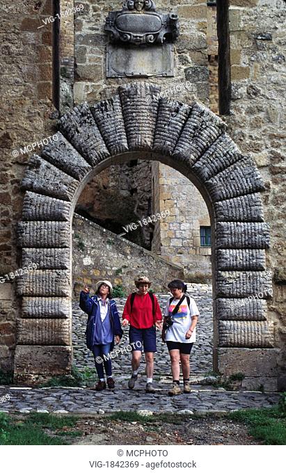 Travelers walk through an archway leaving SORANO, a MEDIEVAL HILL TOWN with a 15th Cent. Palace & Castle - TUSCANY, ITALY MR - 31/07/2009