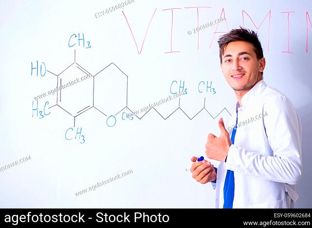 Young chemist standing in front of the whiteboard