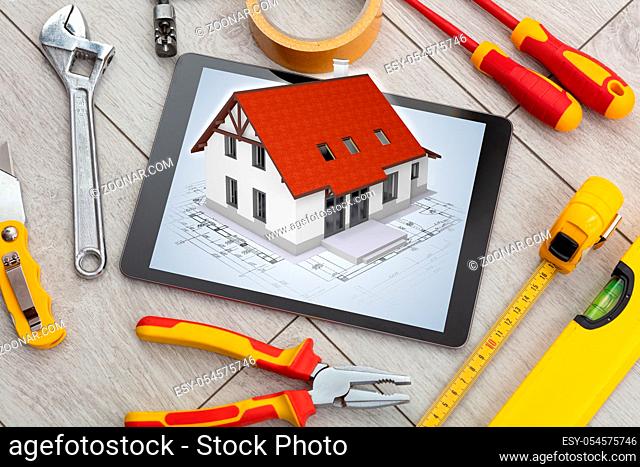 Tablet with construction tools and 3d home plan concept