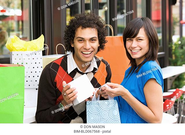 Couple in cafe with shopping bags