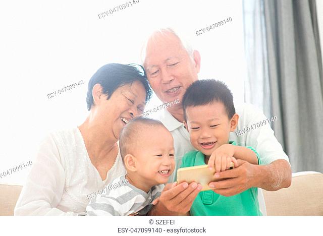 Grandparents and grandchildren taking selfie using smart phones