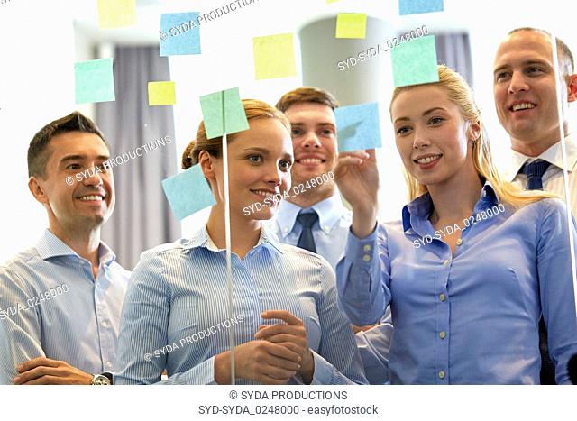 business team at glass wall with sticky notes