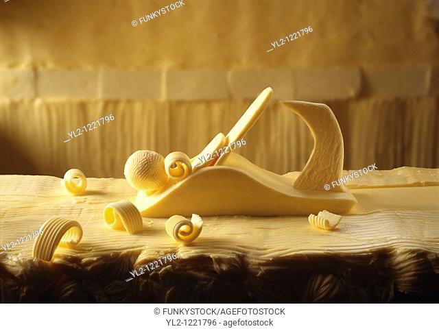 Plane made out of butter on a bitter worktop with butter curls