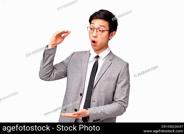 Waist-up portrait of excited good-looking asian office worker telling client about big income opportunities, describe project shaping big object