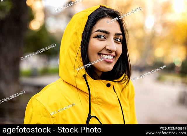 Happy young woman wearing raincoat