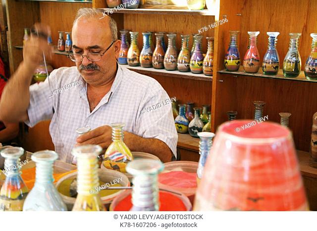 An artist filling souvenir bottles with desert sand, Jerash, Jordan