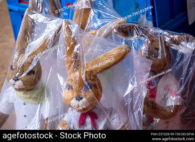 PRODUCTION - 12 October 2023, Mecklenburg-Western Pomerania, Schwerin: An Easter bunny family is tucked under foil bags, waiting on one of the storage shelves...