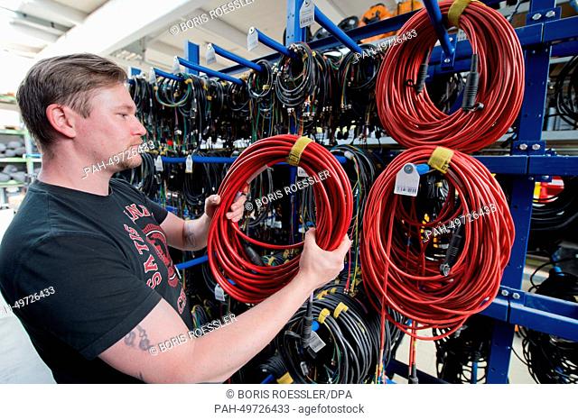 An employee of Satis & Fy sorts cables in the company warehouse in Karben, Germany, 23 June 2014. Business is booming for the event technology