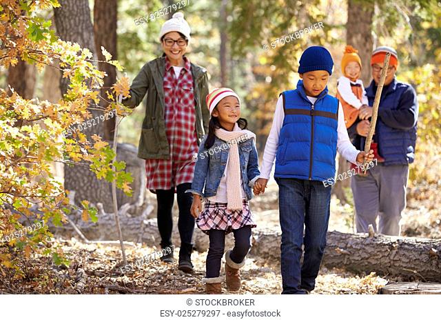Asian family of five enjoying a hike in a forest, close up