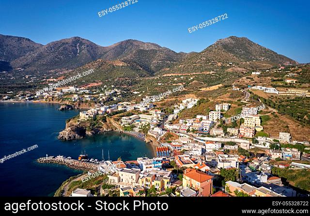 Aerial view of resort village Bali. Crete, Greece. In the foreground the sea, Limani beach harbor and buildings. In the background are mountains under a blue...