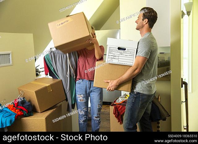 Young couple with boxes moving in to new home