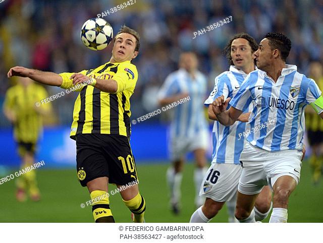 Dortmund's Mario Goetze and Malaga's Manuel Iturra (C) and Weligton vie for the ball during the UEFA Champions League quarter final first leg soccer match...