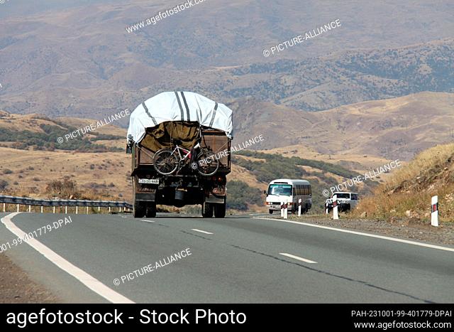 30 September 2023, Armenia, -: A truck packed with belongings of refugees from Nagorno-Karabakh is on its way in the serpentine roads of the South Caucasus