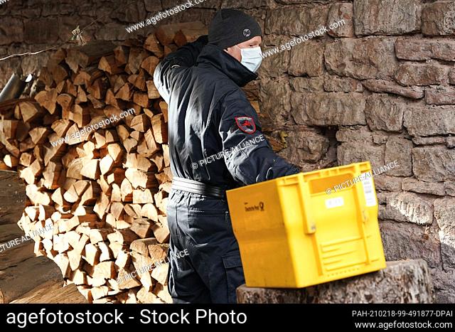 18 February 2021, Rhineland-Palatinate, Fischbach: An employee of the Explosive Ordnance Disposal Service stands by a pile of wood