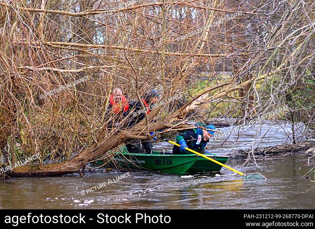 12 December 2023, Saxony-Anhalt, Zerbst: Robert Frenzel (l-r), Hannes Frenzel and Jens Windheuser from the Institute of Inland Fisheries Potsdam-Sacrow sail on...