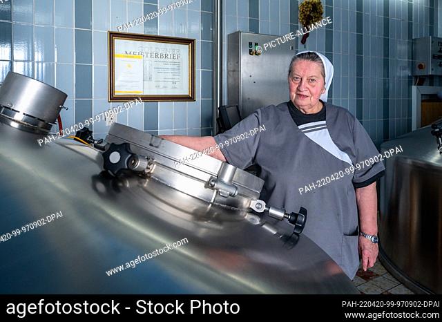 14 April 2022, Bavaria, Mallersdorf-Pfaffenberg: Sister Doris, brewmaster and nun at the Mallersdorf monastery, stands at a brew kettle in the monastery brewery