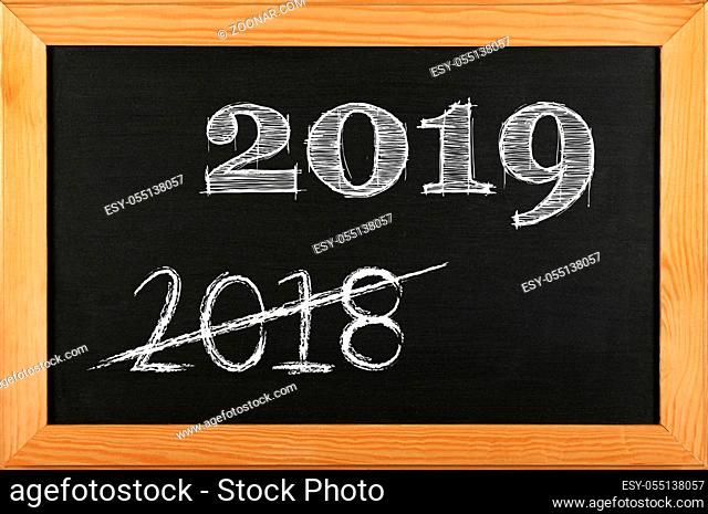 Black school chalkboard blackboard sign in brown wooden frame with 2019 and 2018 strikethrough chalk text
