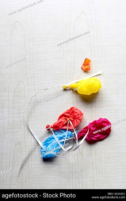 Shriveled colorful balloons on a white ribbon