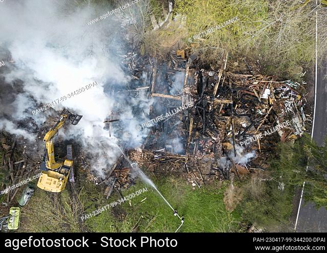17 April 2023, Hesse, Wüstefeld: Firefighters extinguish the still smoking debris of the former farm of the ""cannibal of Rotenburg"", Armin M