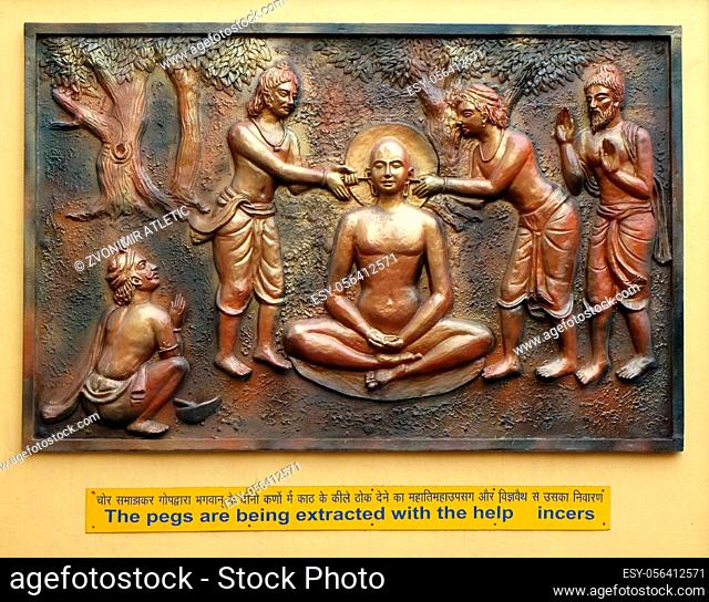 The pegs are being extracted with the help incers, Street bas relief on the wall of Jain Temple (also called Parshwanath Temple) in Kolkata, West Bengal, India