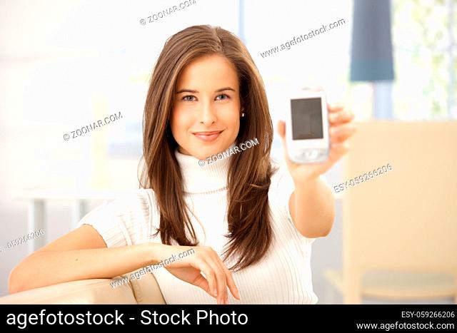 Portrait of smiling woman holding cellphone up to camera