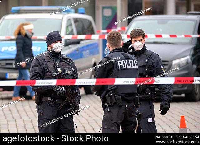 31 January 2022, Schleswig-Holstein, Neumünster: Police officers stand in front of the widely cordoned off train station