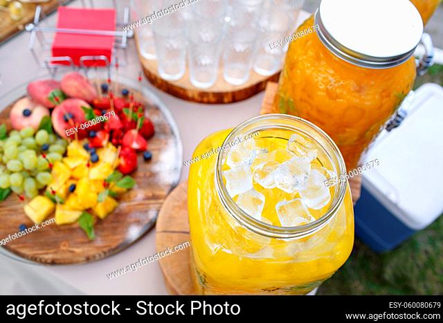 Jar of tasty fresh lemonade with ice and mint. appetizers, canapes and bruschetta on background. the fourchette in the open air. professional catering