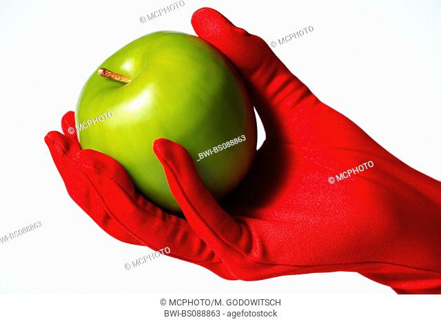 green appel held in hand with red glove