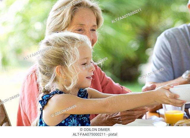 Girl having meal with family outdoors