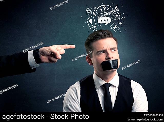 Caucasian business hand pointing at stressed male employee with drawn question, explamation marks, talk bubble above his head