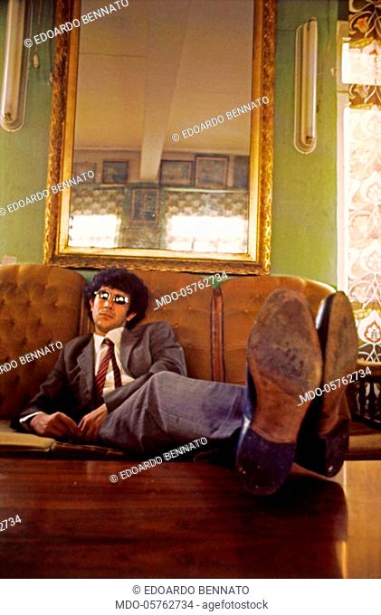 The singer-songwriter Edoardo Bennato sitting on a sofa. Italy, 1981