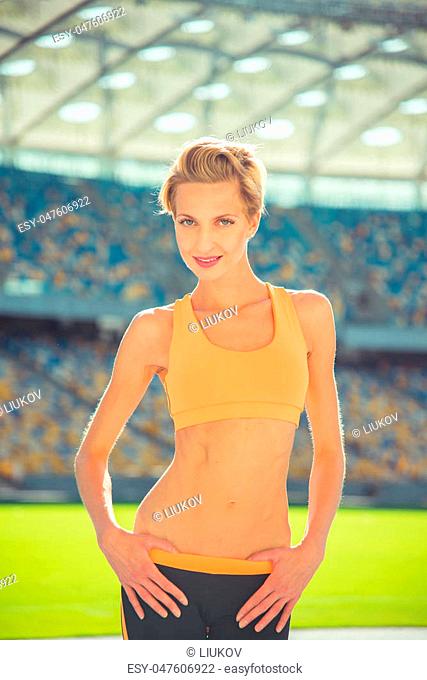 Sport girl in sport clothes standing on the stadium