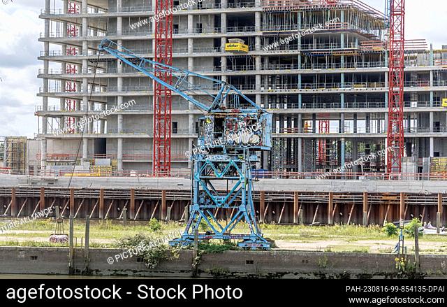 13 August 2023, Hamburg: A historic harbor crane stands on the Billhafen loading dock in front of the Elbtower construction site at the Elbe bridges