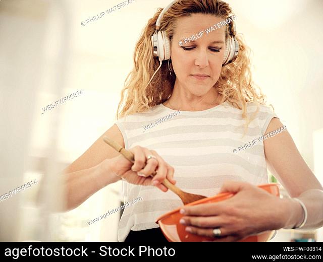 Woman preparing food while listening music at home