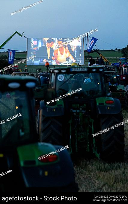 26 August 2023, Lower Saxony, Harsum: Several tractors are lined up on a field in the Harsumer Feldmark in front of a set-up screen