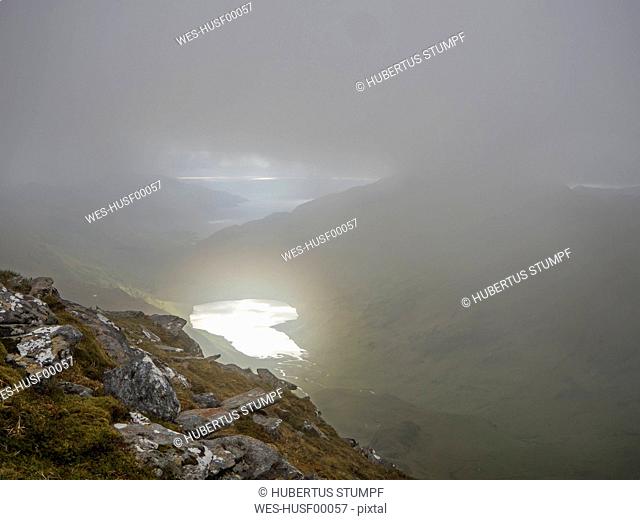 High angle view of lake amidst mountains against cloudy sky during foggy weather, Scotland, UK