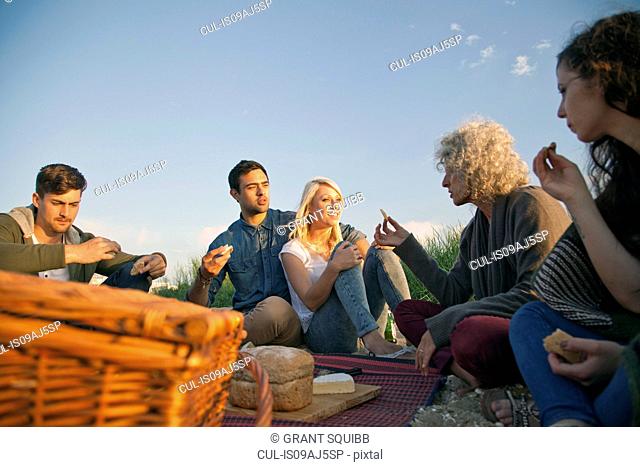 Five adult friends having picnic on Bournemouth beach, Dorset, UK