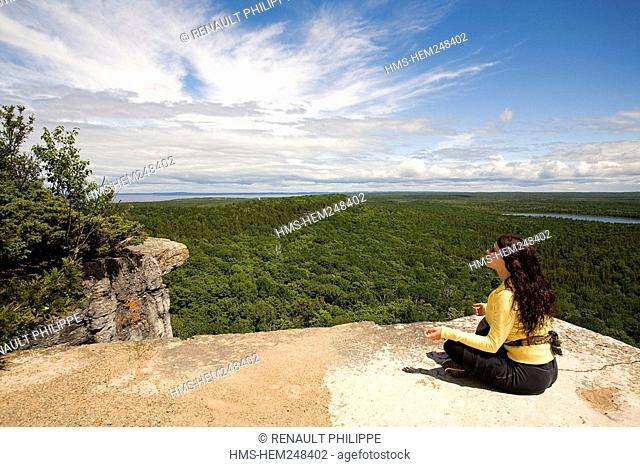 Canada, Ontario Province, Manitoulin Island, hiking at Cup and Saucer, woman at the edge of a cliff admiring the view