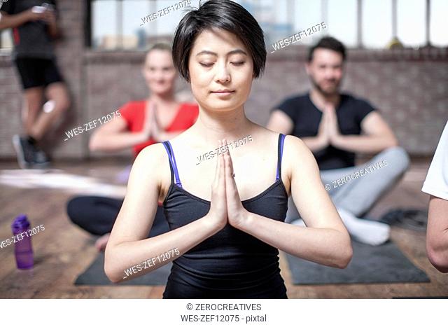 Young woman doing yoga meditaiton exercise in studio