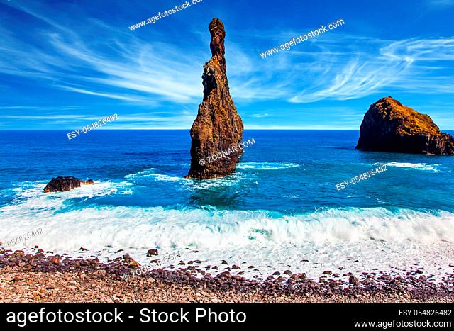 Magic travel on the volcanic island of Madeira. Three huge scenic rocks near the pebble beach. Concept of exotic and ecological tourism