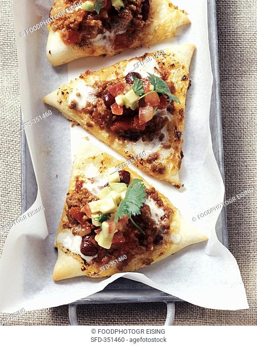 Triangles of tarte flambée with chili con carne topping