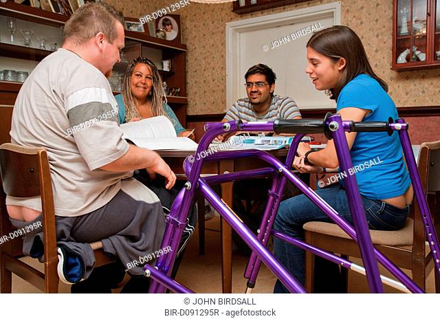 Young white student, who has Cerebral Palsy and uses a walking frame, in multiracial study group