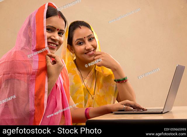 Two rural women sitting together with a laptop
