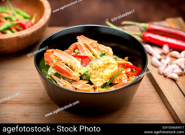 Delicious Thai Food Stir Fried crab in yellow curry on wooden