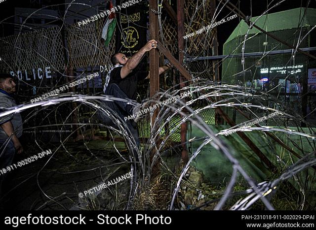 18 October 2023, Lebanon, Beirut: A protestor climbs a wall outside the US Embassy during a protest in solidarity with the people of Gaza to condemn a strike...